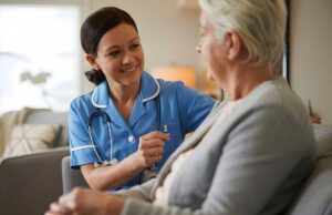 A nurse assists an older adult with medication in a cozy living room setting.